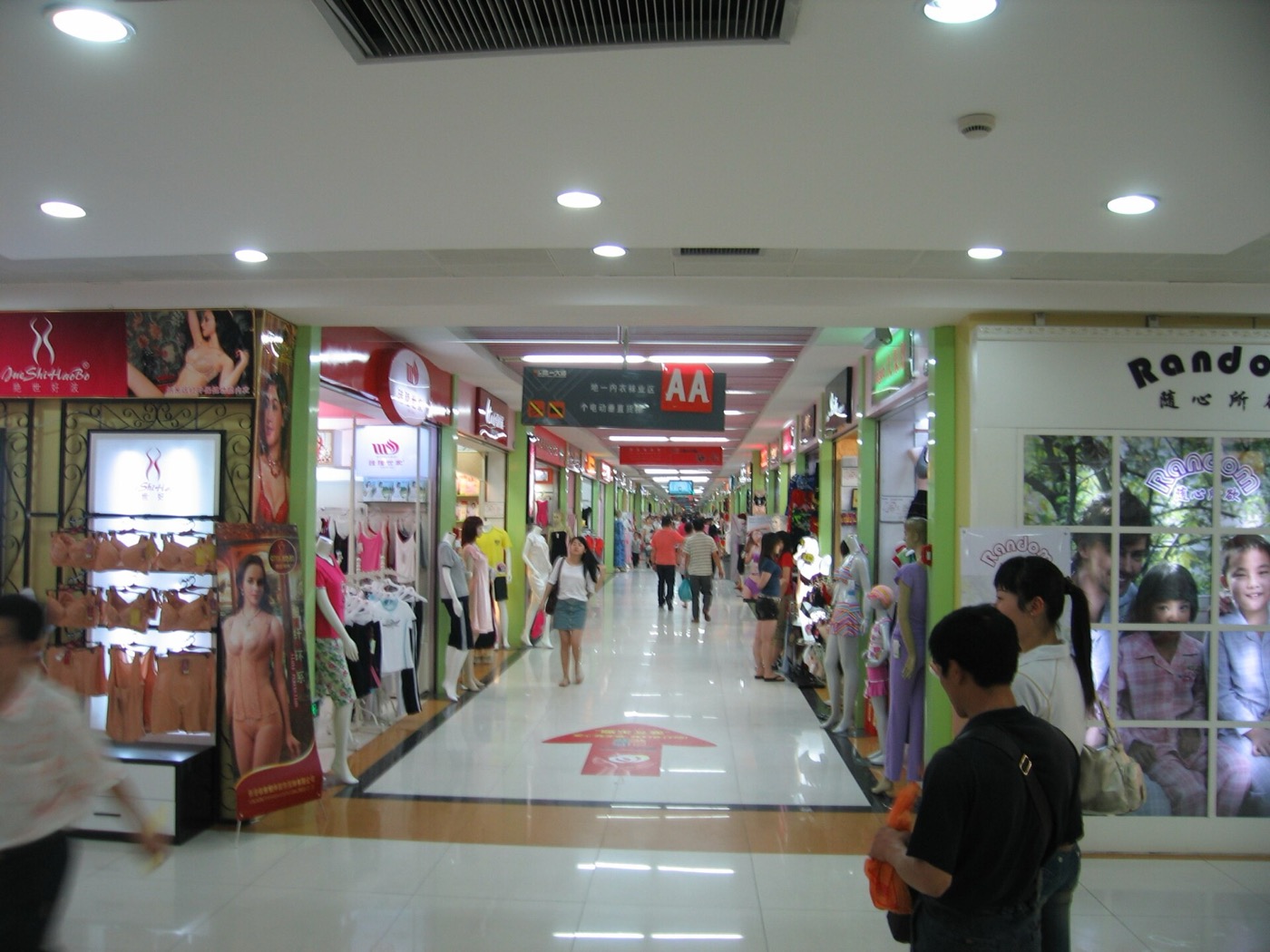 Inside a wholesale market in Guangzhou, with goods stacked in shop units along a corridor